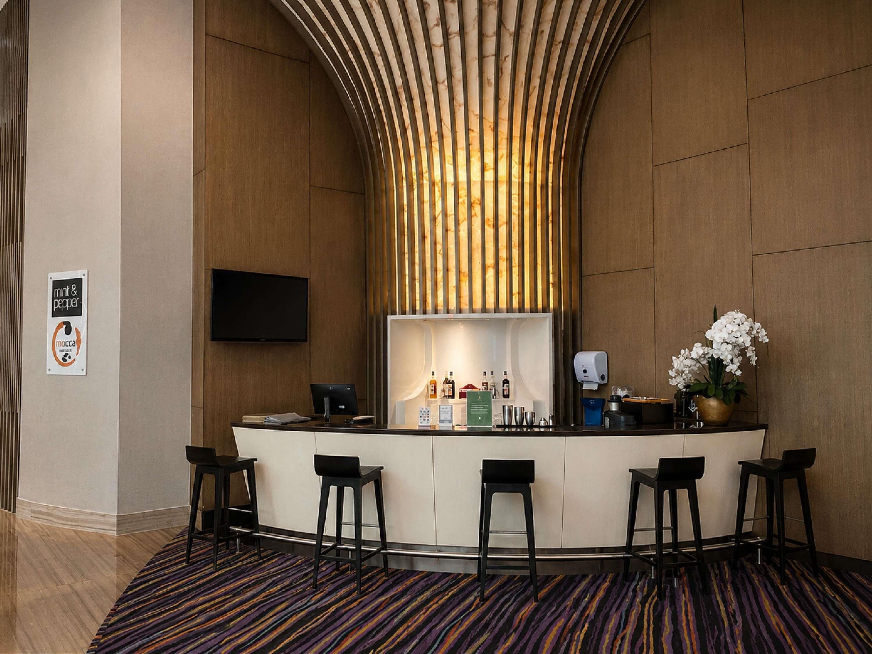 A bar area with a curved counter, bar stools, a television, and a sign indicating a non-smoking area.