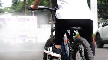 Una persona montando bicicleta en un espacio abierto con una estructura cubierta encima.