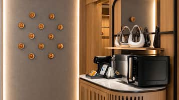 Una cocina moderna con cafetera, microondas y utensilios sobre la encimera.