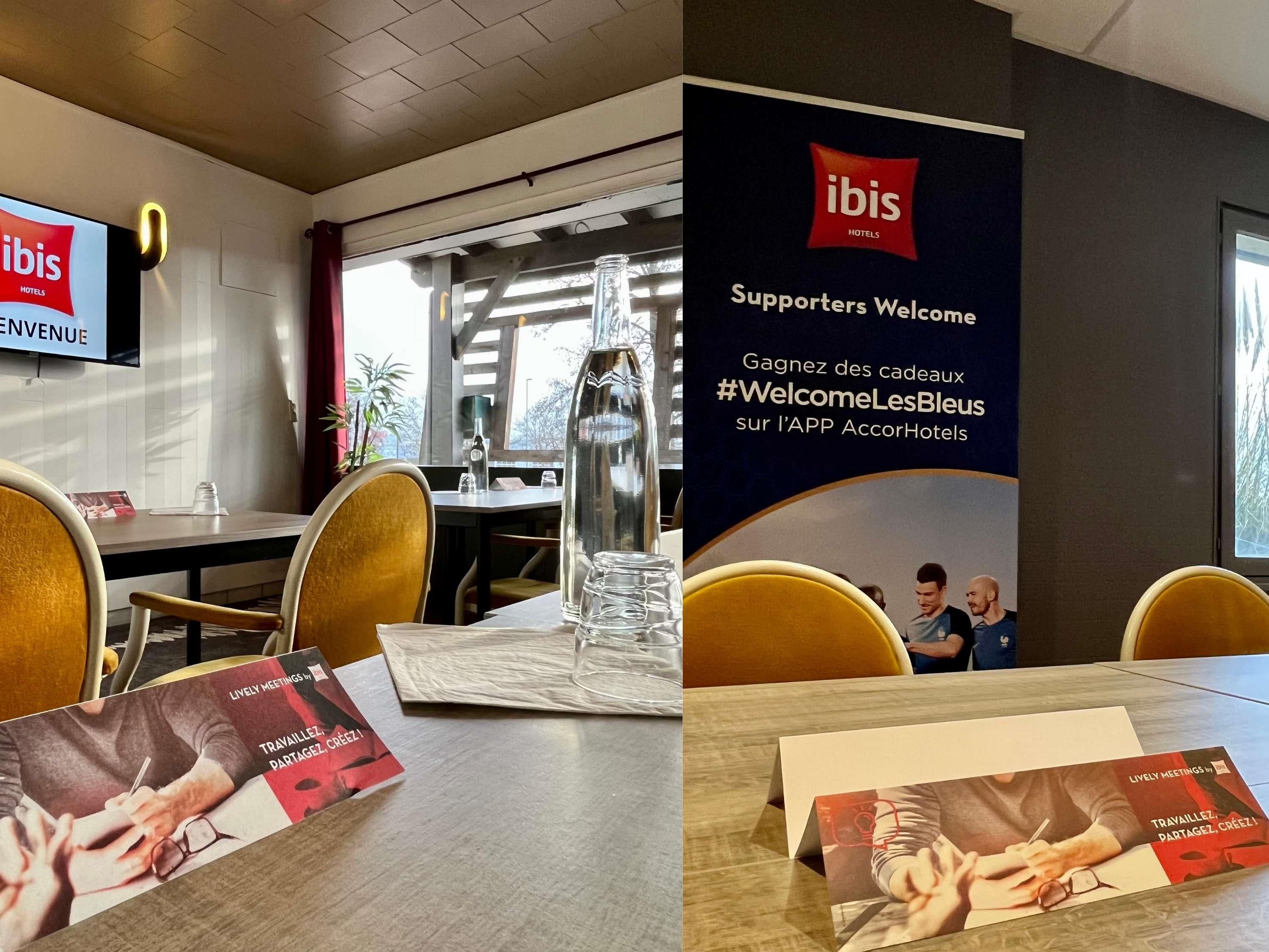 A hotel reception area with a large sign welcoming supporters, a television displaying the hotel's name, and brochures on the table.
