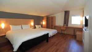 A hotel room with a large bed, bedside tables, a desk, a chair, a television, and a window with curtains. - ibis Aurillac (Aurillac)
