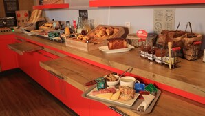 A breakfast buffet with various food items, including pastries, cheeses, and condiments. - ibis Aurillac (Aurillac)