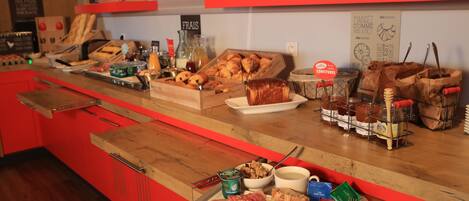 A breakfast buffet with various food items, including pastries, cheeses, and condiments.