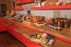 A breakfast buffet with various food items, including pastries, cheeses, and condiments.