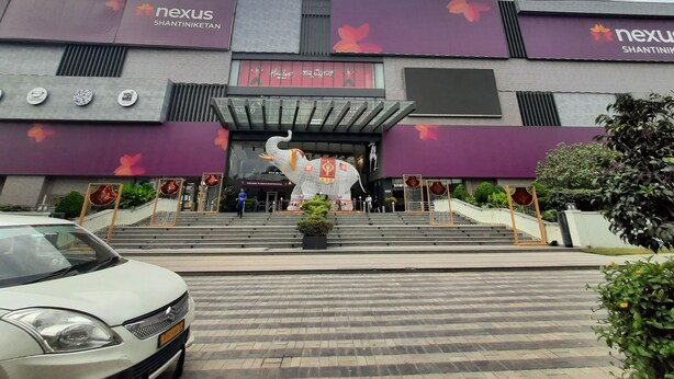 A modern building with a large entrance, a statue, and a car parked in front. - Holiday Inn Express Bengaluru Whitefield Itpl by IHG (Bengaluru)
