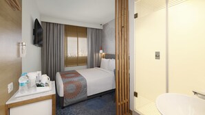 A hotel room with a bed, a desk with a coffee maker, a TV, and a bathroom with a toilet and sink. - Holiday Inn Express Bengaluru Whitefield Itpl by IHG (Bengaluru)