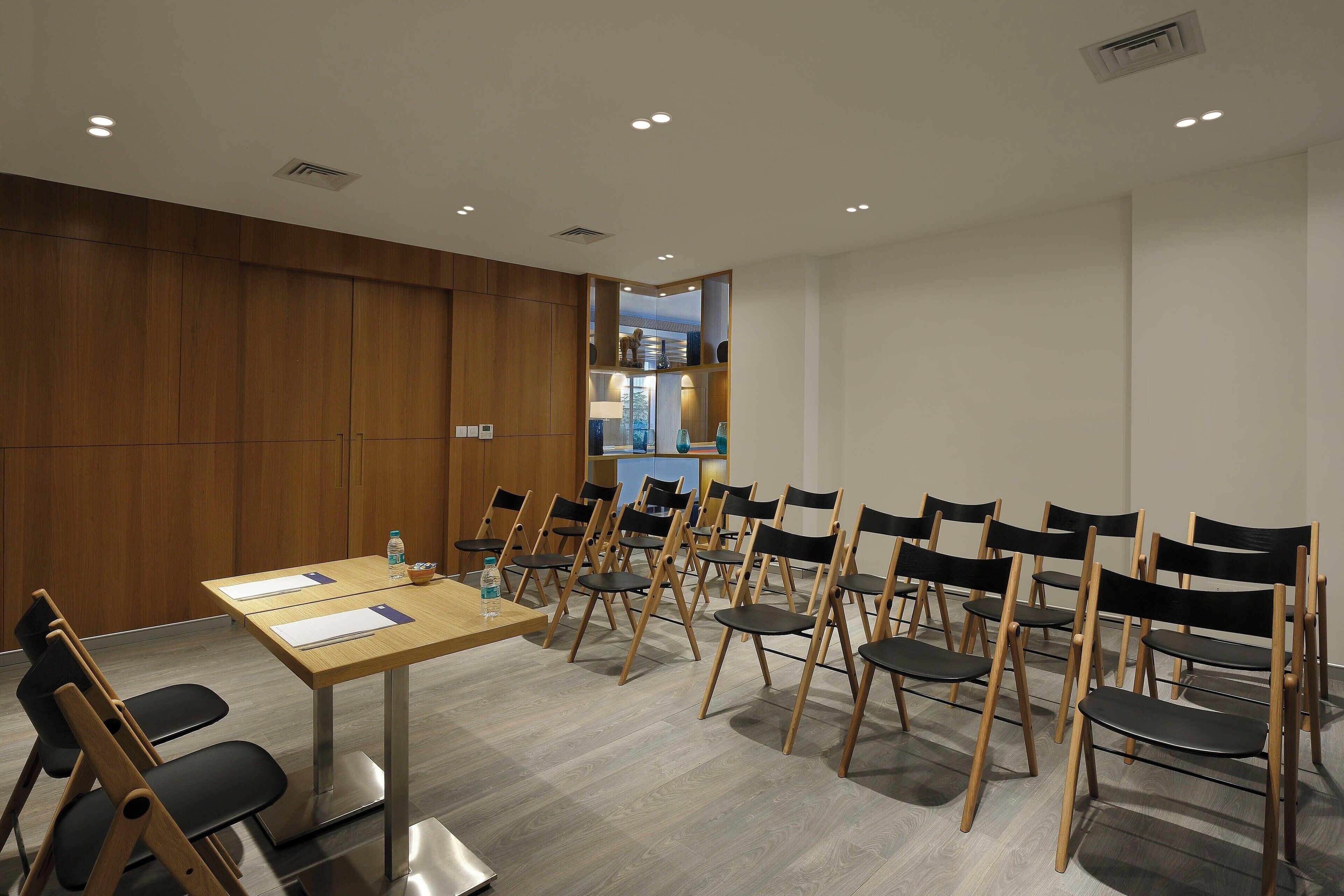 A conference room with a long table, multiple chairs, and a water bottle on the table.