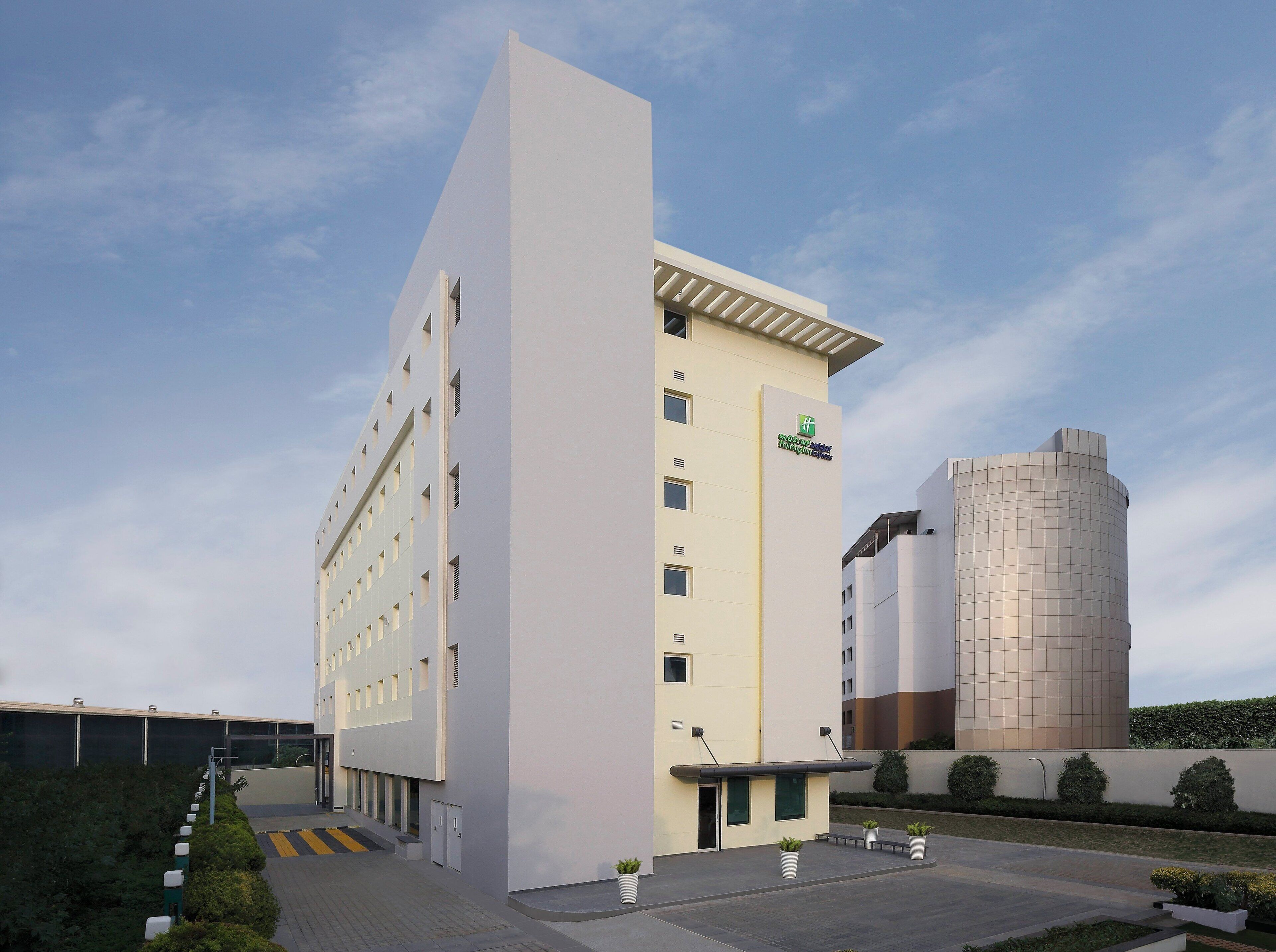 A modern building with a flat facade, multiple windows, and a logo on the side.