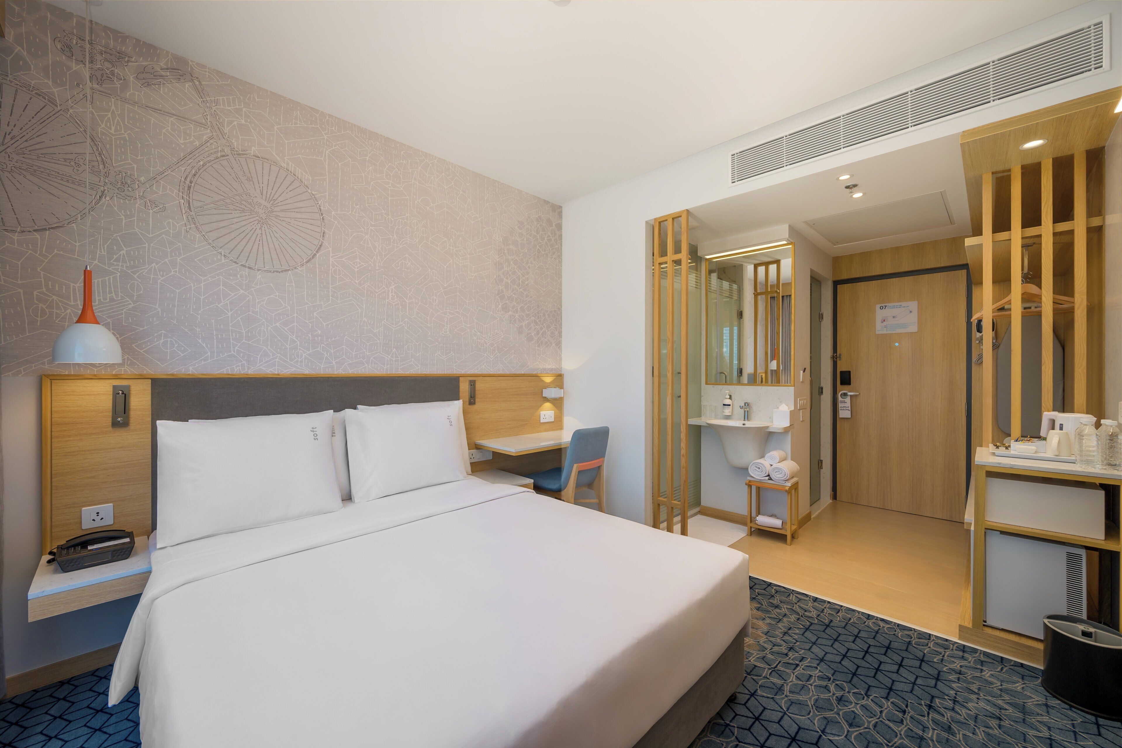 Een hotelkamer met een groot bed, een bureau, een stoel, een kledingkast en een badkamer.