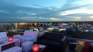 A rooftop lounge with white and black sofas, a coffee table, and a red decorative lamp. - Fiesta Inn Chetumal Hotel (Chetumal)