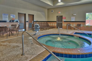 A pool area with lounge chairs, a hot tub, and a reception desk. - Holiday Inn Express Hotel & Suites Lubbock South by IHG (Lubbock)