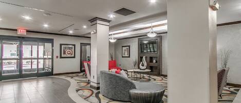 A lobby with a curved seating area, a reception desk, and a large pillar.