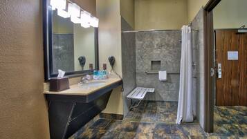 Un baño con lavamanos, espejo y ducha.