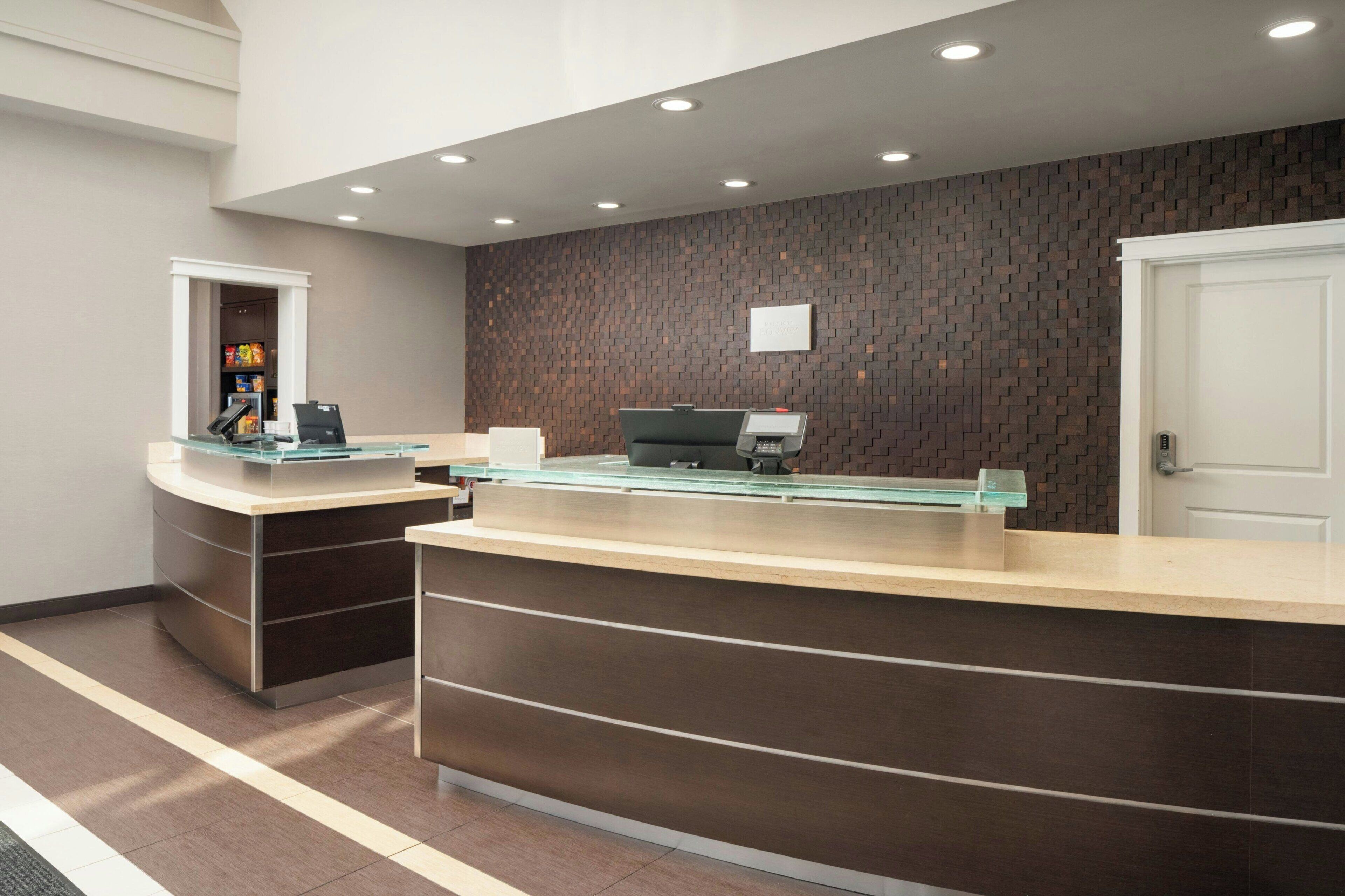 A reception area with two counters, a wall-mounted display, and a door.