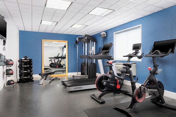 A gym with cardio equipment, weight machines, and a mirror. - Capitol Plaza Hotel Montpelier Tapestry Collection by Hilton (Montpelier)