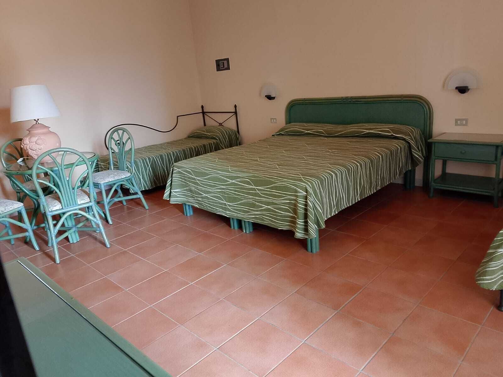 Habitación cuádruple básica | Minibar, caja de seguridad en la habitación, escritorio y ropa de cama 