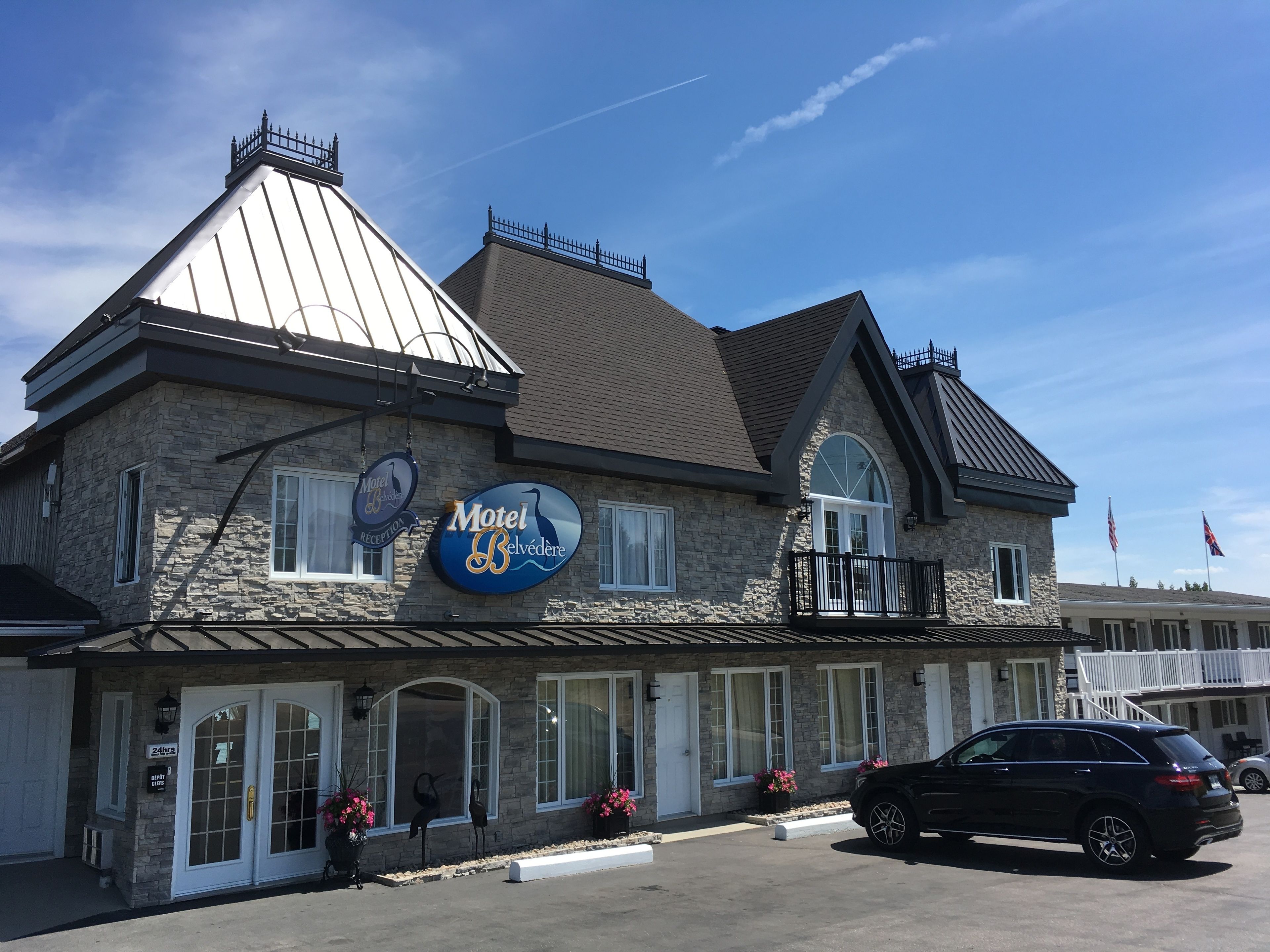A two-story stone building with a sign reading "Motel Belvédère."