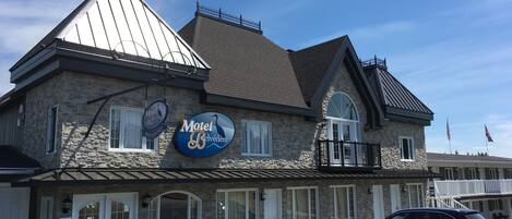 A two-story stone building with a sign reading "Motel Belvédère."