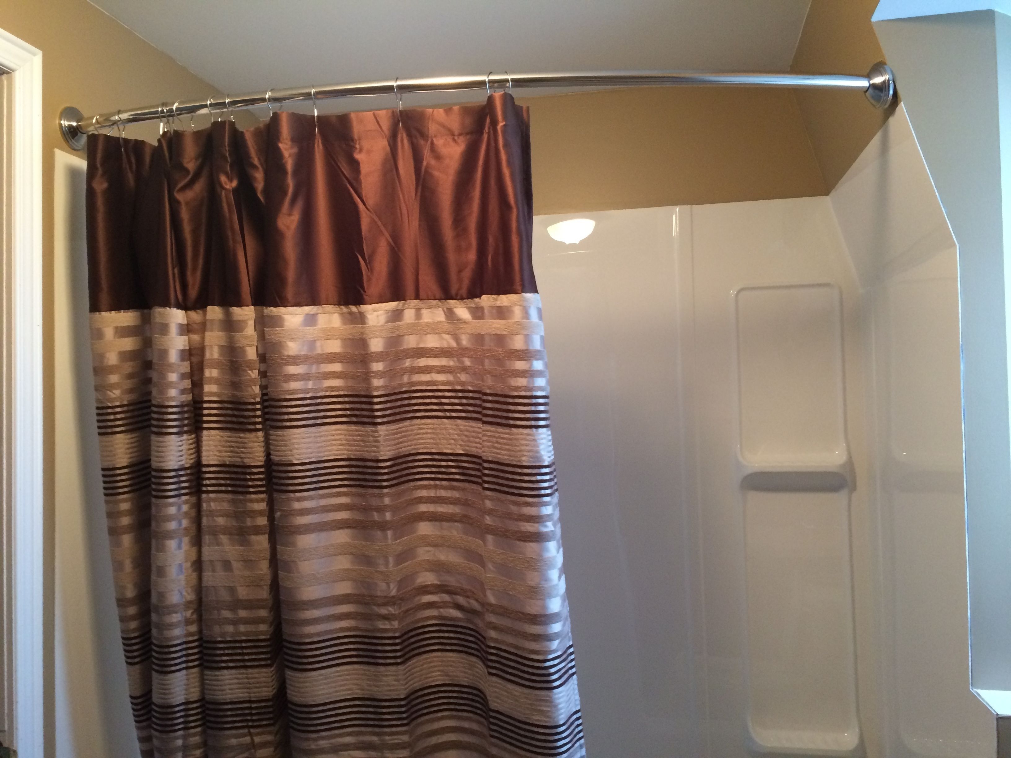 Une salle de bain avec un rideau de douche, une porte blanche et un espace douche.