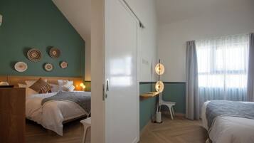 A hotel room with two beds, a desk, and a wardrobe.