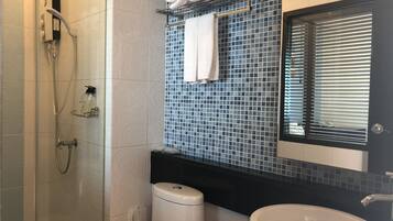 Une salle de bain équipée d’une douche, de toilettes, d’un lavabo et d’un porte-serviettes avec des serviettes.