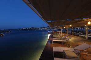 A waterfront deck with lounge chairs and a view of the city at dusk. - Olira Boutique Hotel & Spa - Boutique Class (Bodrum)