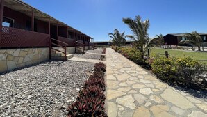 A pathway leading to a building with a stone facade and a thatched roof.