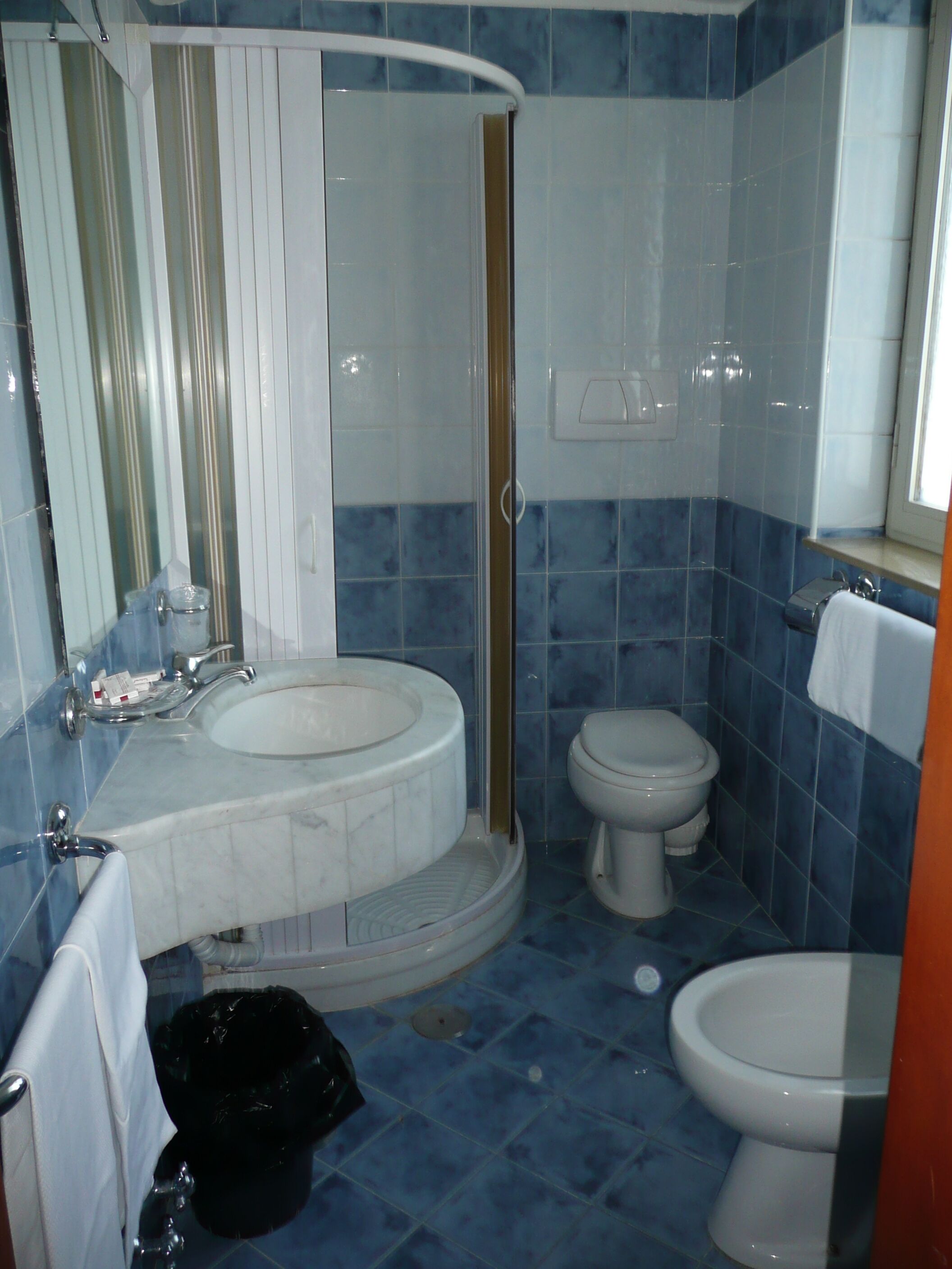 Une salle de bain avec deux lavabos, des toilettes et une douche.