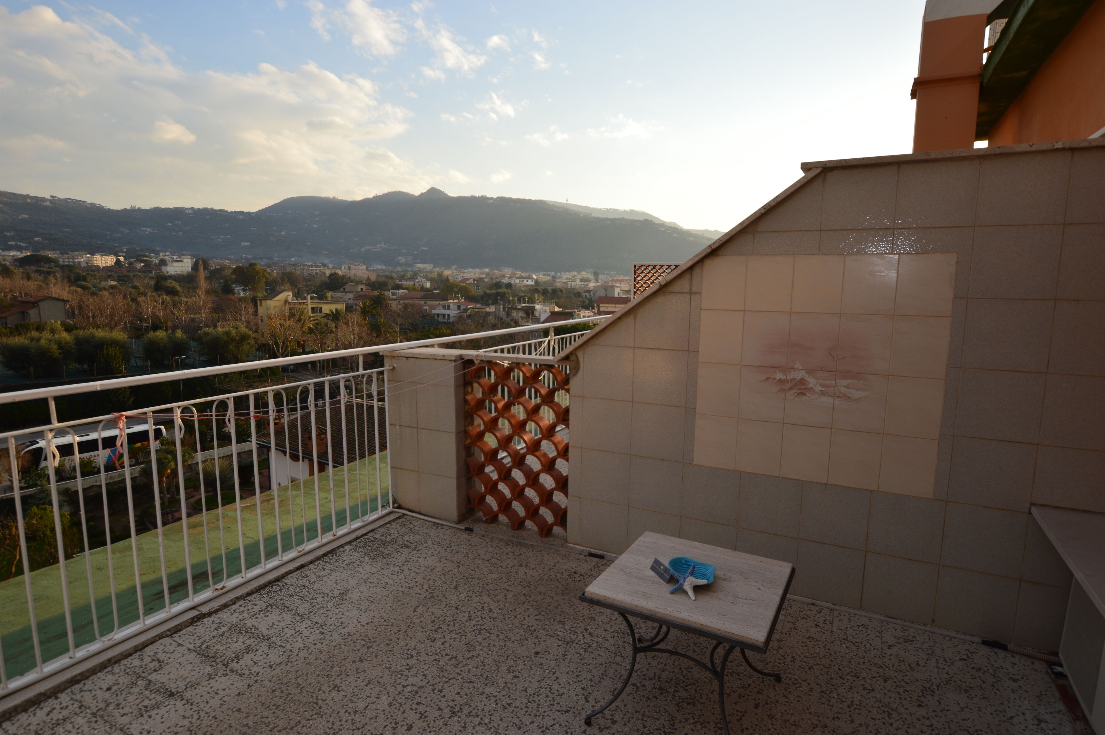 Un balcon avec vue sur la ville et les montagnes.