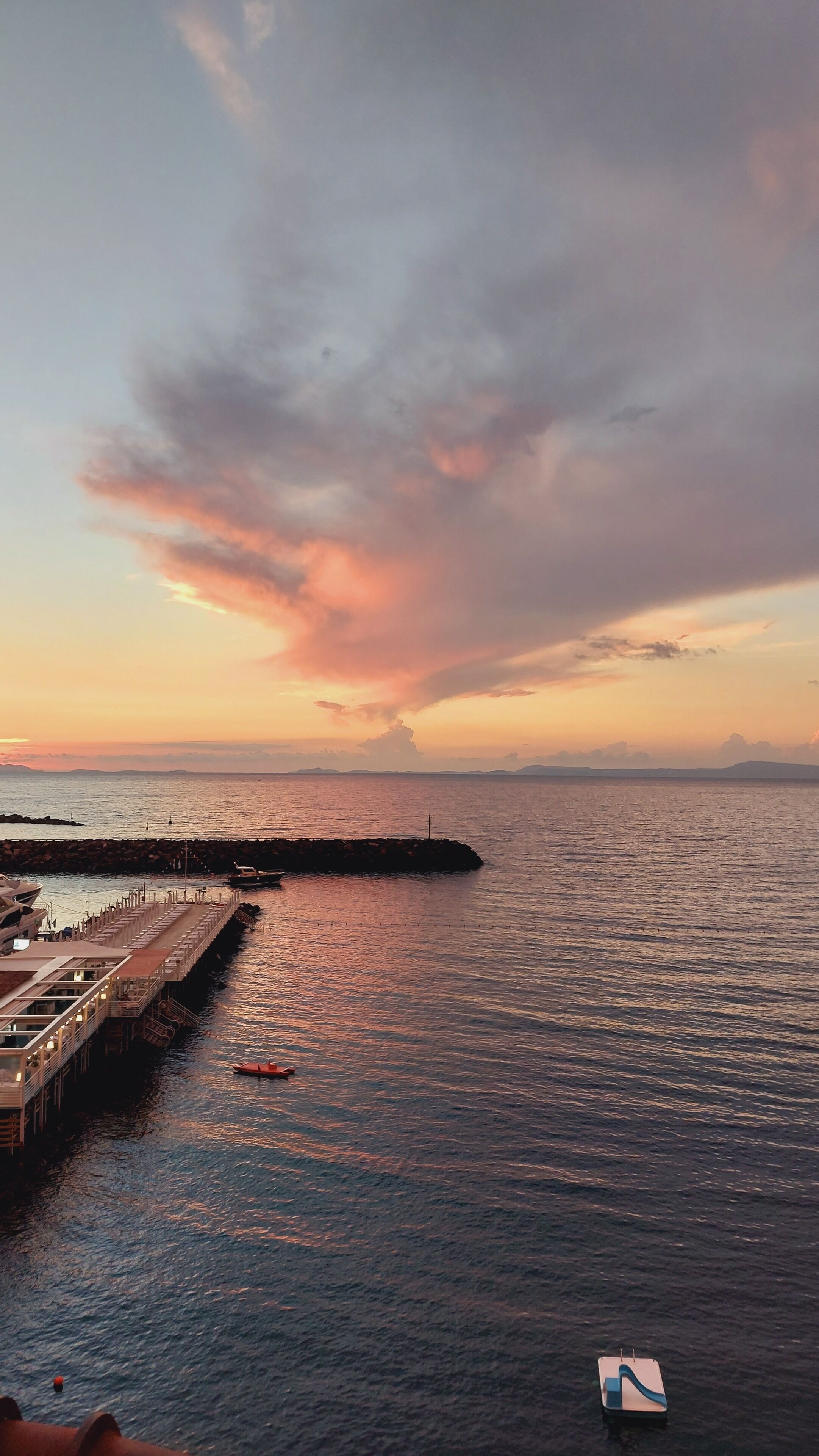 Un muelle frente al agua con un restaurante y barcos.
