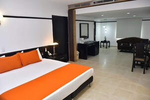 Una habitación de hotel con una cama grande, un escritorio, un sofá y un espejo.