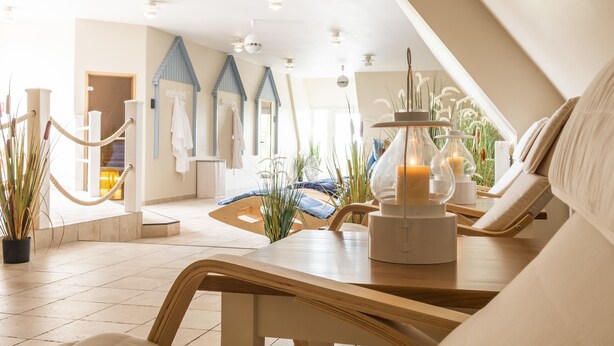 Un spa moderno con un banco de madera, una mesa con velas y vistas al área del spa.