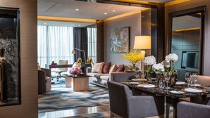 A modern hotel room with a dining area, a sofa, a coffee table, and a TV. - Four Seasons Hotel Shenzhen (Shenzhen)