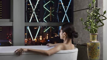 Enjoy a relaxing soak in the bathtub with a view of the city skyline.