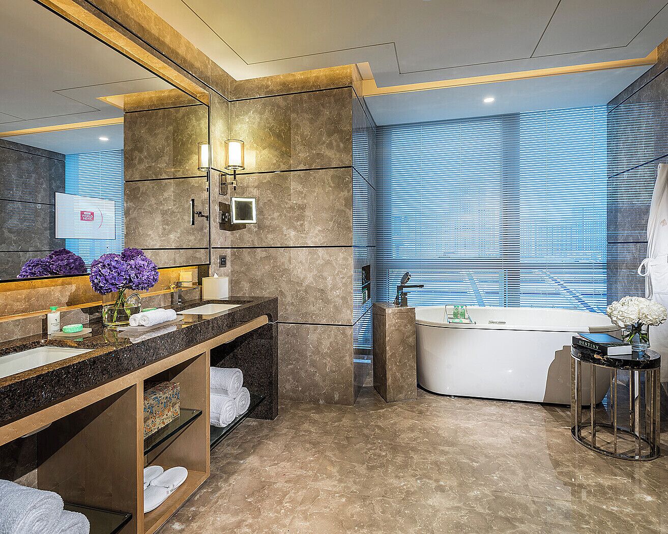 Un baño moderno con un espejo grande, una bañera y un lavamanos.