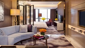 A modern hotel room with a sofa, coffee table, and a TV. - Four Seasons Hotel Shenzhen (Shenzhen)
