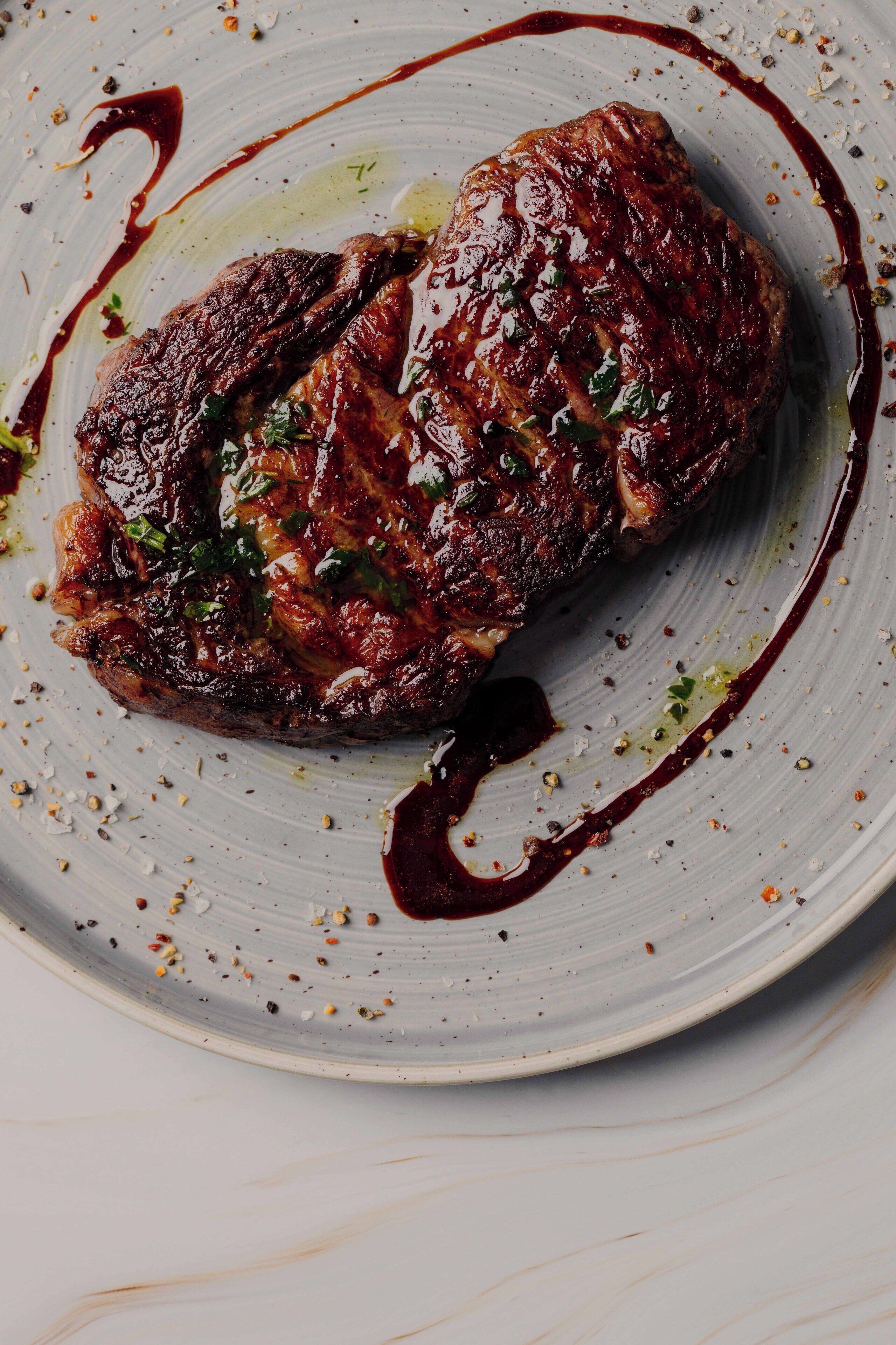 A steak with sauce on a plate.