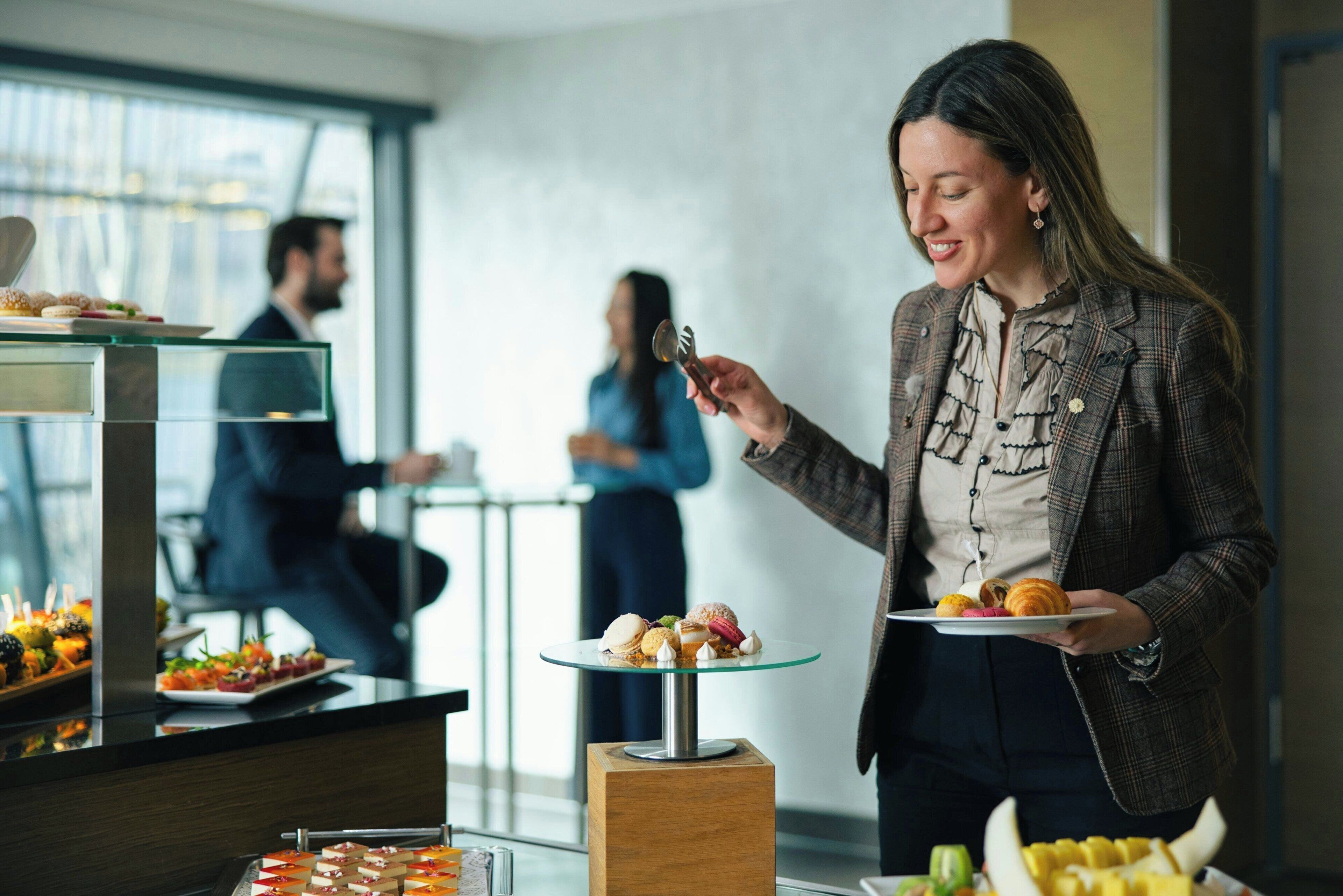 A buffet setup with various food items and a person serving.