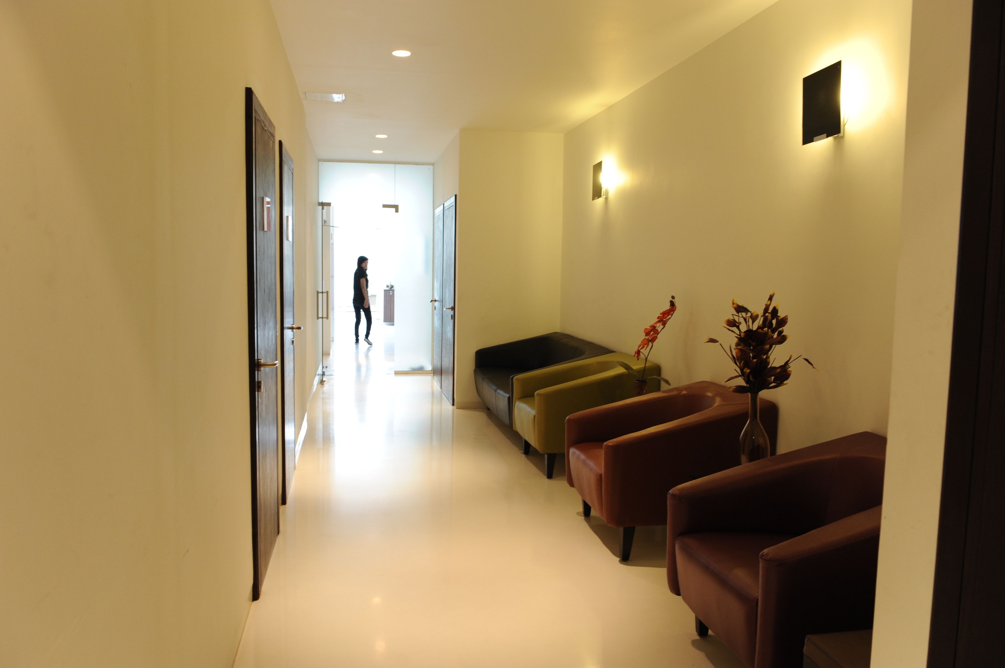 Un vestíbulo de hotel con un largo pasillo, zona de estar y mostrador de recepción.