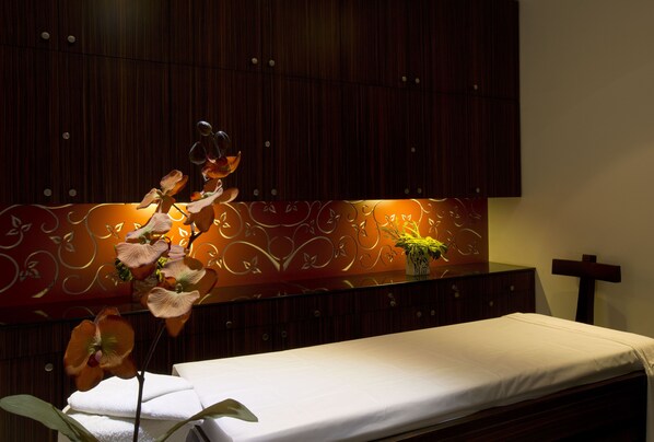 A room with a bed, a wooden cabinet, and a wall with a decorative pattern. - SRS Springs Hotel & Spa (Bengaluru)