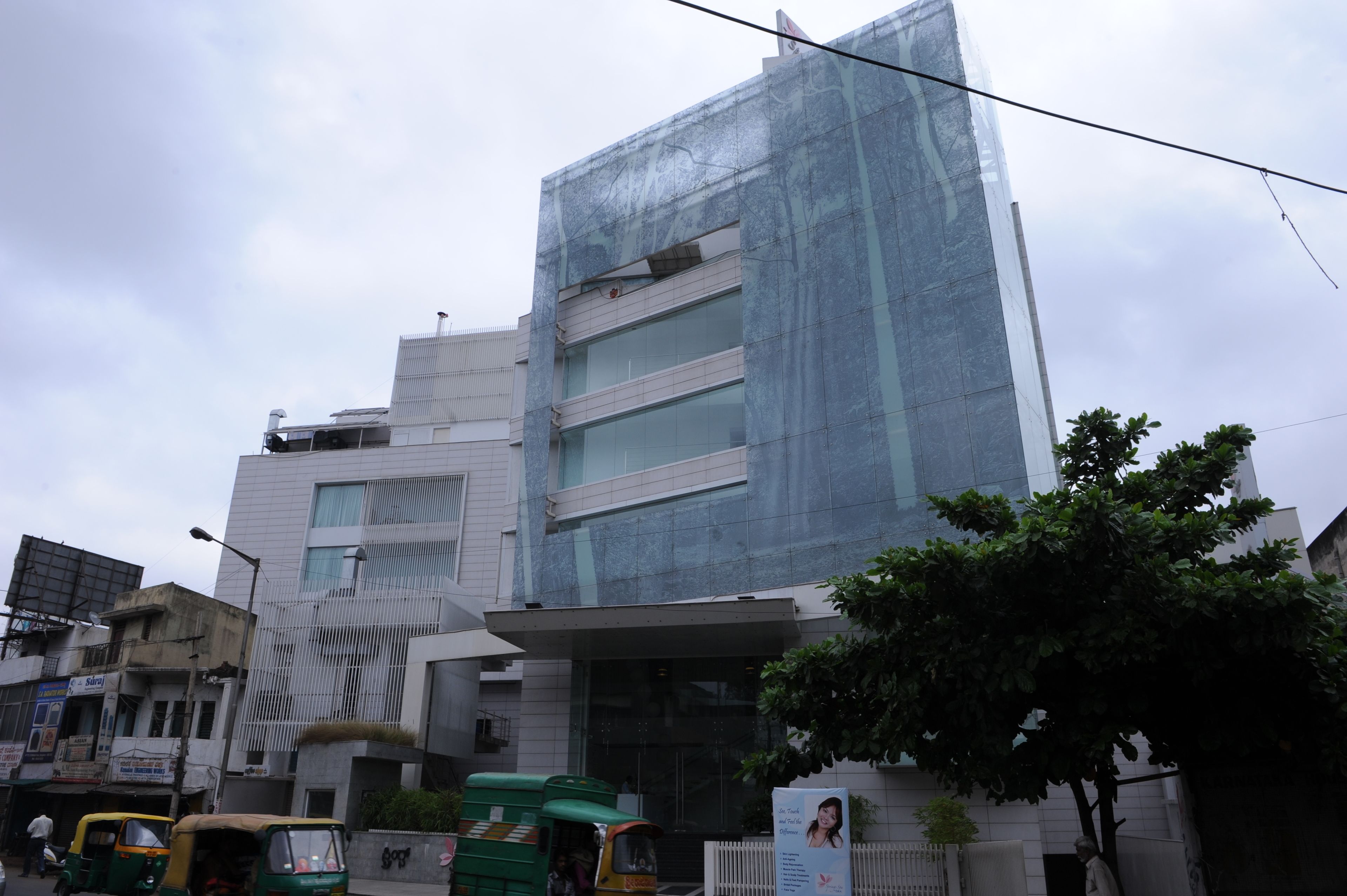 Un bâtiment moderne doté d’une façade en verre, de plusieurs étages et d’une entrée imposante.