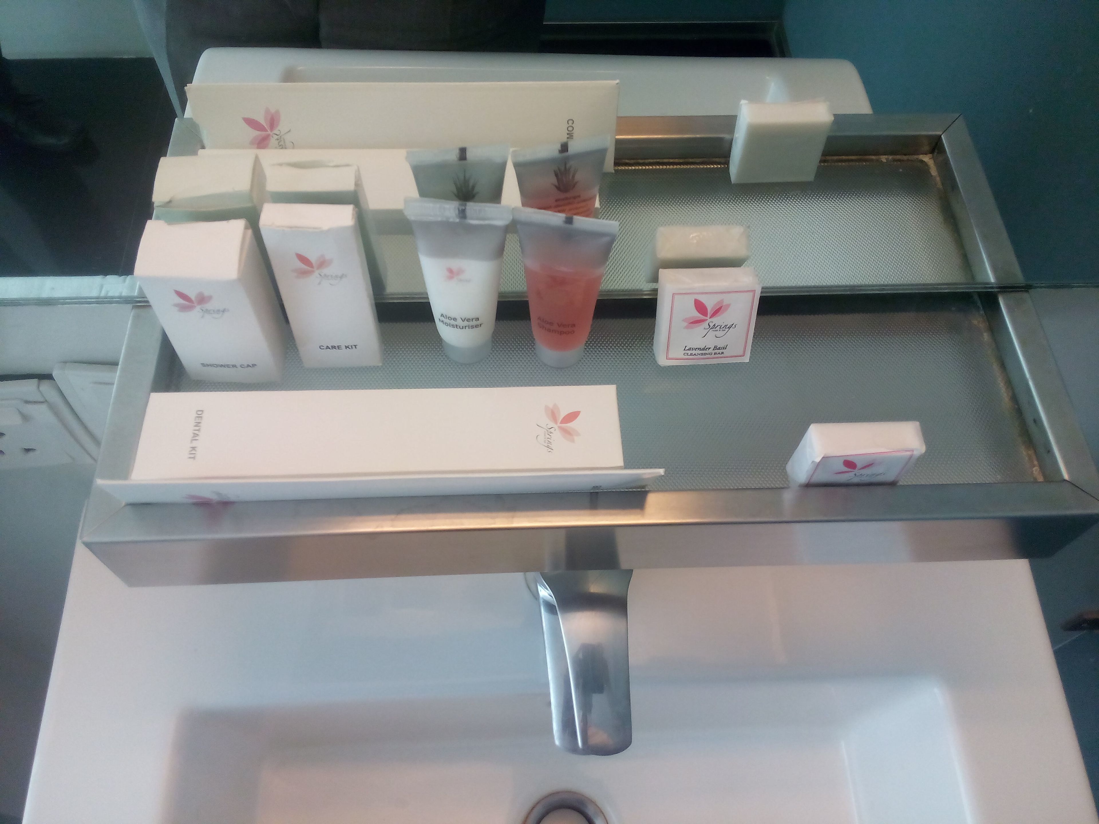 Ein Badezimmer-Waschtisch mit verschiedenen Pflegeprodukten und einem Waschbecken.