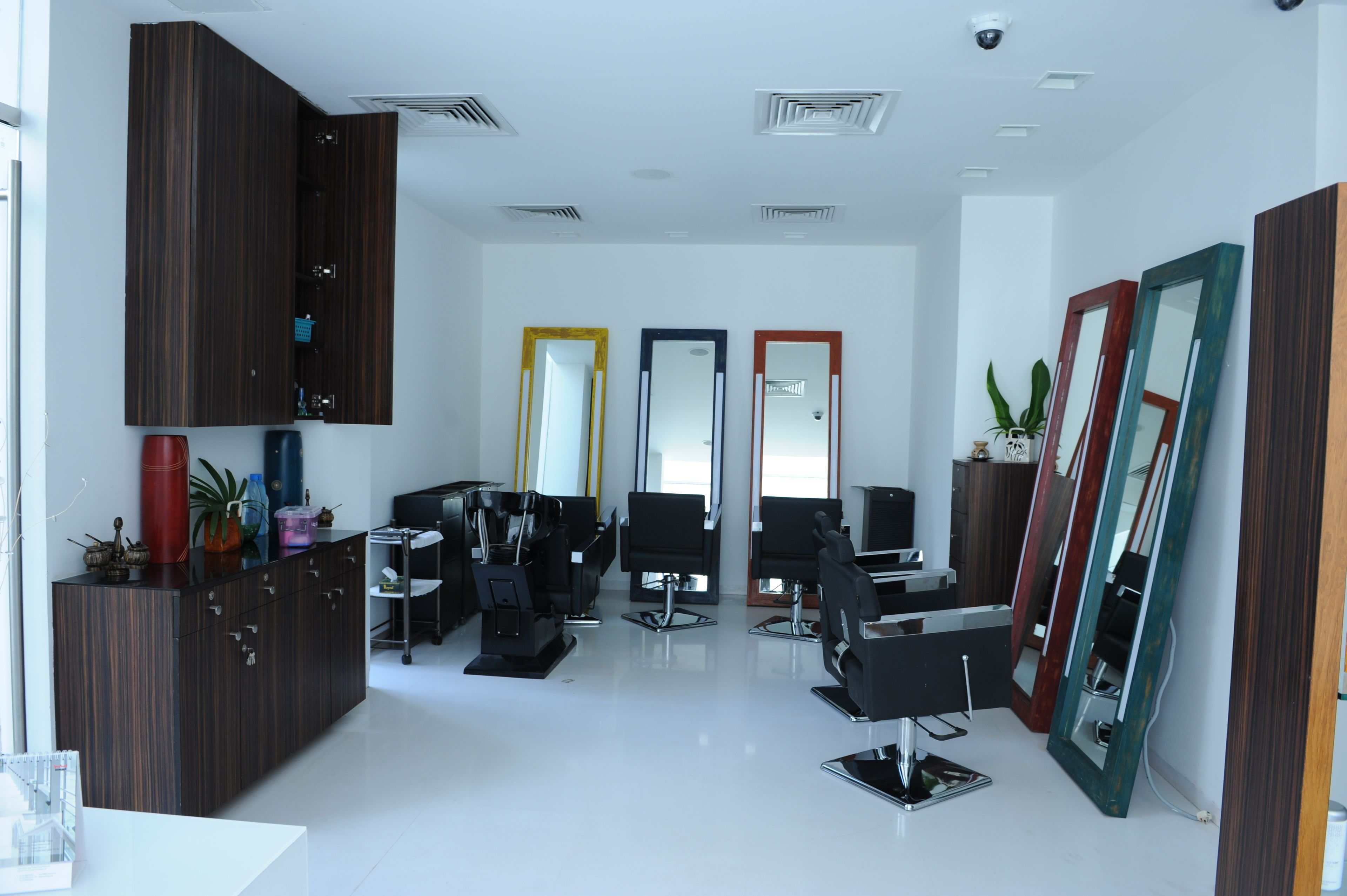 A modern hair salon with multiple chairs, mirrors, and a reception area.