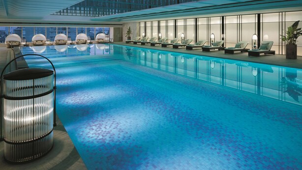 An indoor swimming pool with lounge chairs and a glass ceiling. - Jing An Shangri-La, Shanghai (Shanghai)
