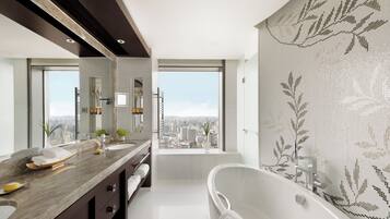 A modern bathroom with a large bathtub, dual sinks, and a city view.