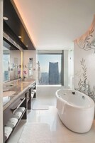 A modern bathroom with a large mirror, two sinks, a bathtub, and a view of a cityscape.