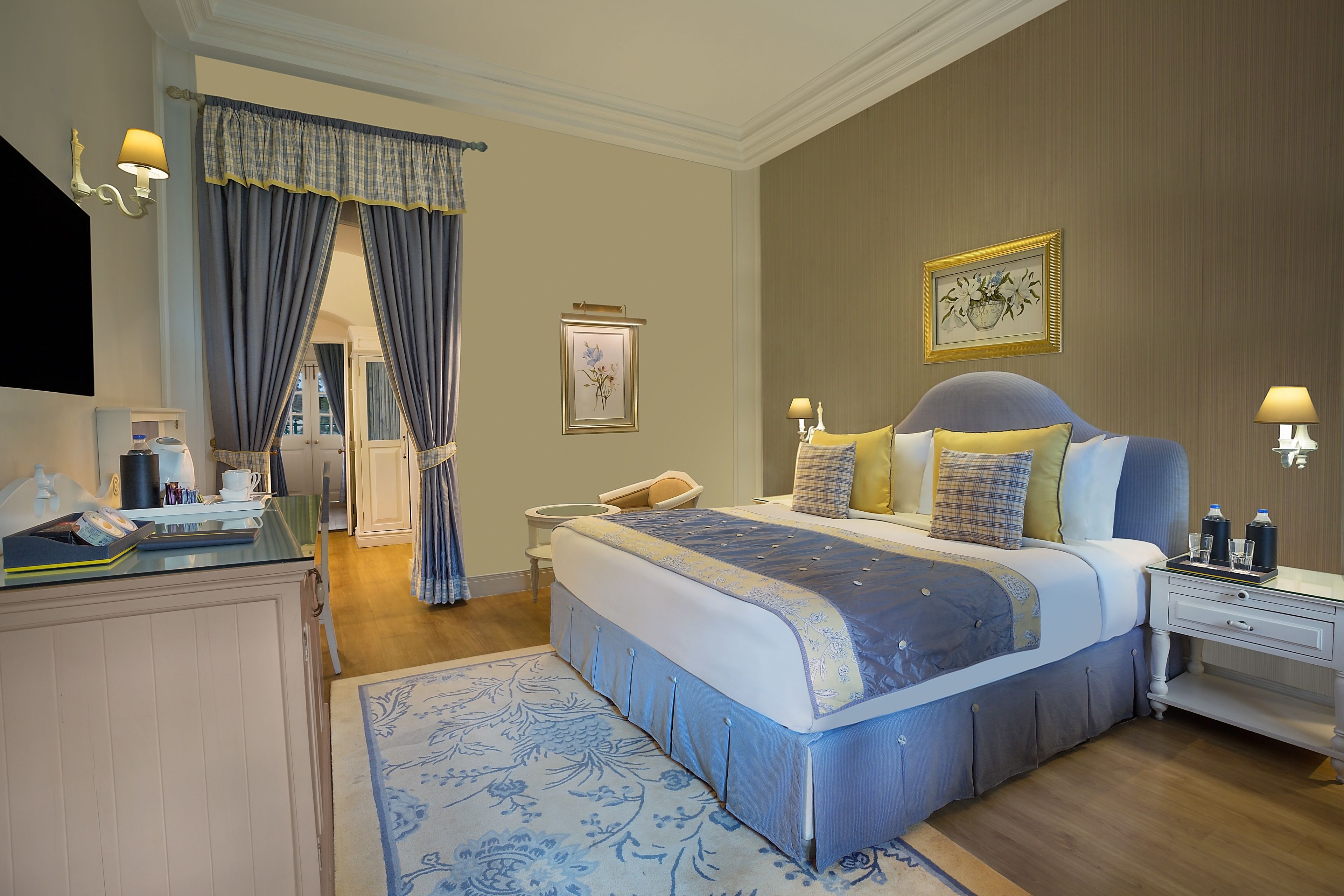 Une chambre d’hôtel avec un grand lit, des tables de chevet, un bureau et une chaise.