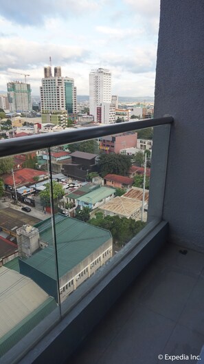 A balcony with a view of a cityscape, including various buildings and a construction crane. - Ace Hotel & Suites (Pasig)