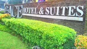 A sign for ACE HOTEL & SUITES with a stone facade and greenery in front. - Ace Hotel & Suites (Pasig)
