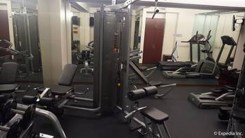 A gym with various exercise equipment including treadmills, weight machines, and dumbbells.